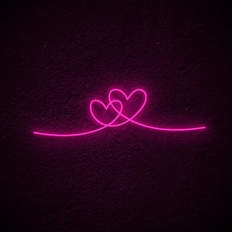 A glowing pink Double Heart Neon Sign, showing two overlapping heart outlines, mounted on a textured wall.