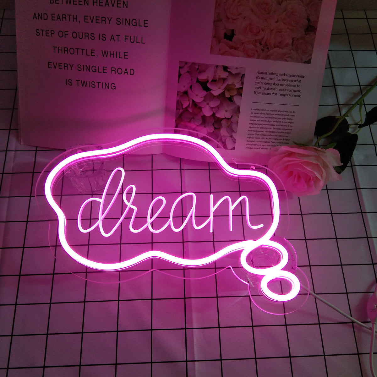 The physical "Dream" USB Mini LED Neon Sign illuminated and glowing, mounted on a wall and viewed from a slight angle, highlighting the acrylic backing and wiring details.
