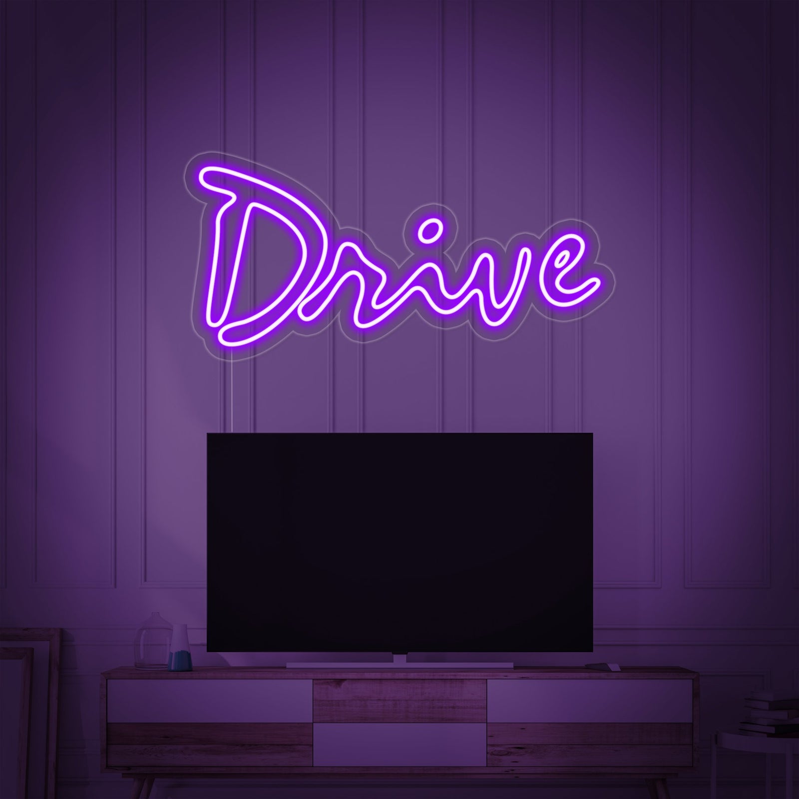A striking 'Drive Movie' neon sign with clear tubing and a visible power cord, casting a bright pink light.
