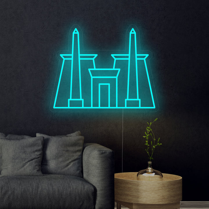 A glowing orange neon sign showing the silhouette of the ancient Egyptian Karnak Temple against a plain, dark, out-of-focus background, highlighting the architecture.