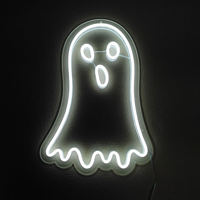 A blue neon sign depicting a retro gaming ghost character against a dark, textured wall.