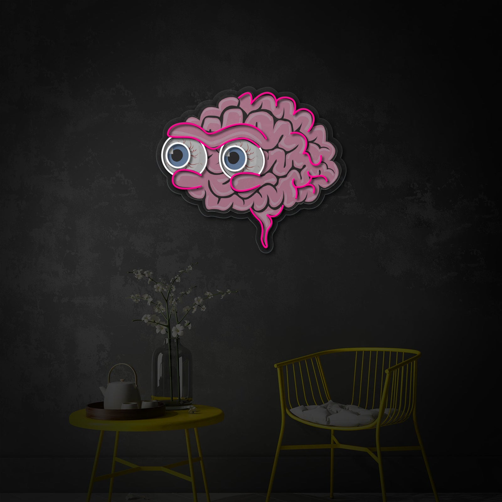 A lifestyle shot of the 'Eyeball Brains' neon sign illuminating a cozy, bohemian-style living space, hung above a chair and next to decorative plants.