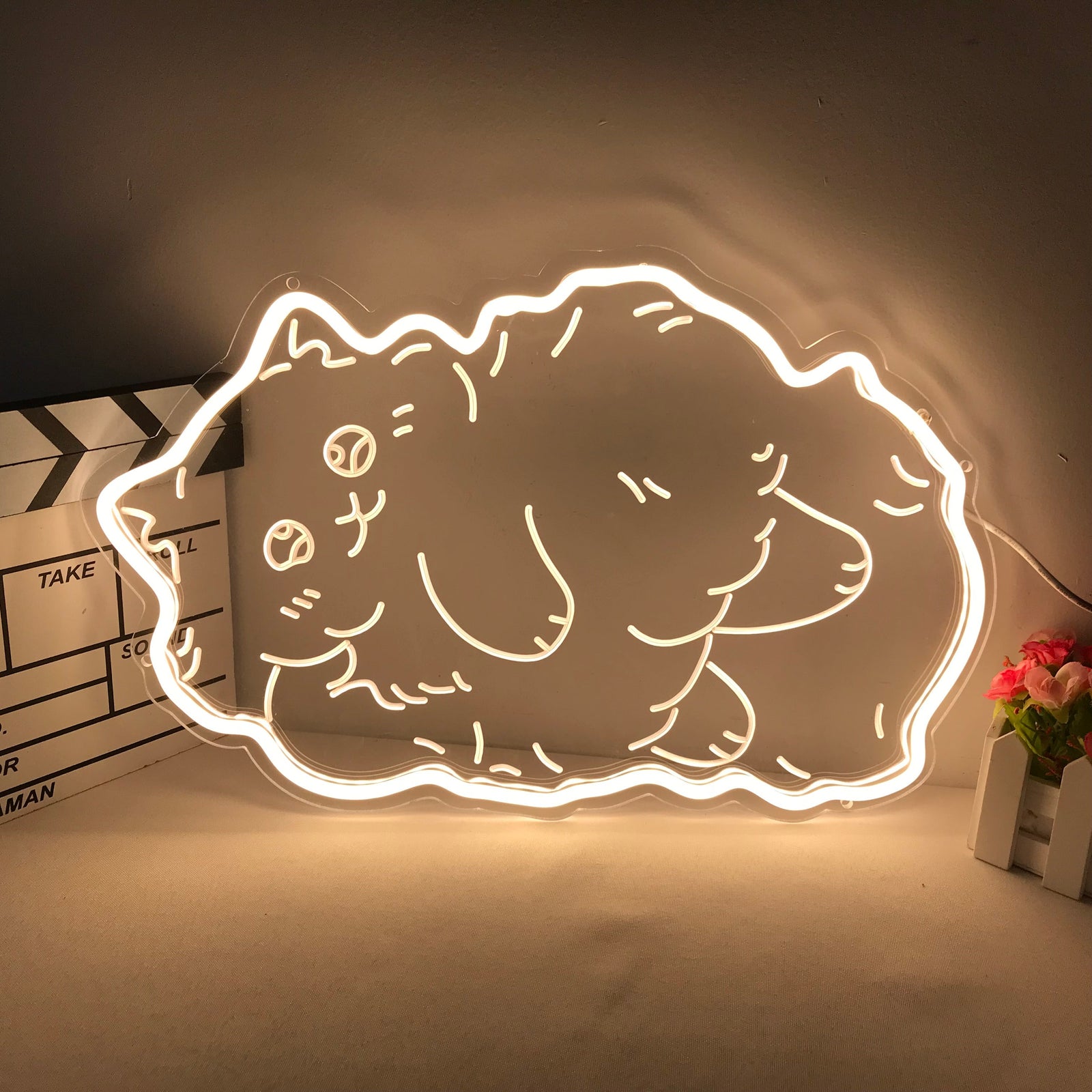 Lit Fatty Cat cartoon mini neon sign glowing pink on an acrylic backing against a soft-focus cozy room background.