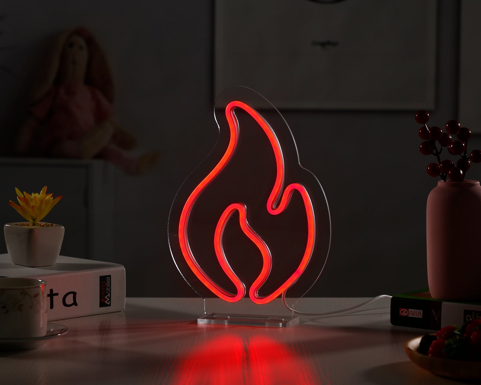 Fire desk neon sign glowing orange and yellow in a dimly lit cozy room setting.