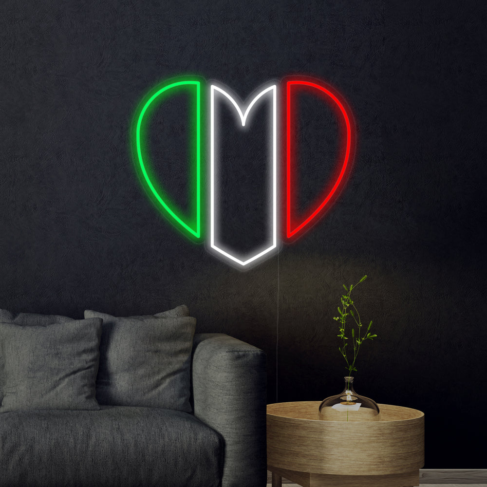 A glowing red, white, and green neon sign in the shape of a heart featuring the Italian flag design mounted on a light-colored wall.