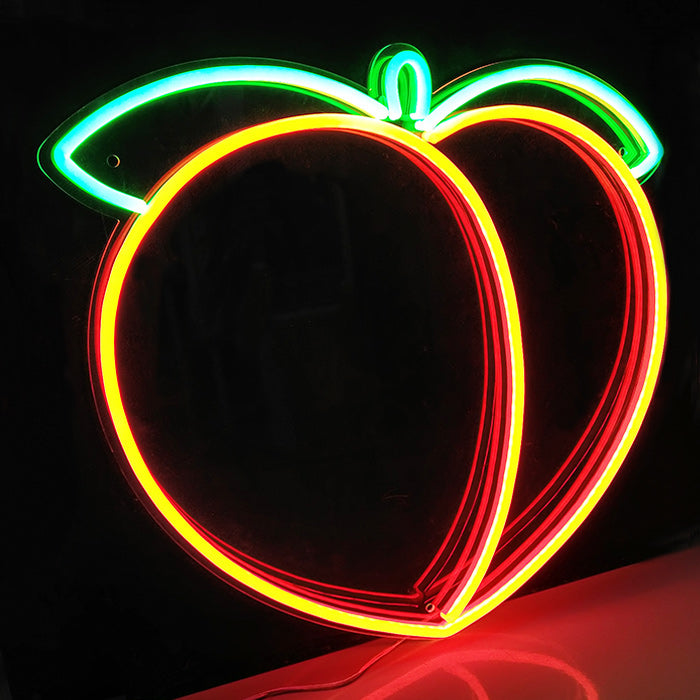 A glowing peach-shaped neon sign with an orange fruit and green leaf mounted on a wall.