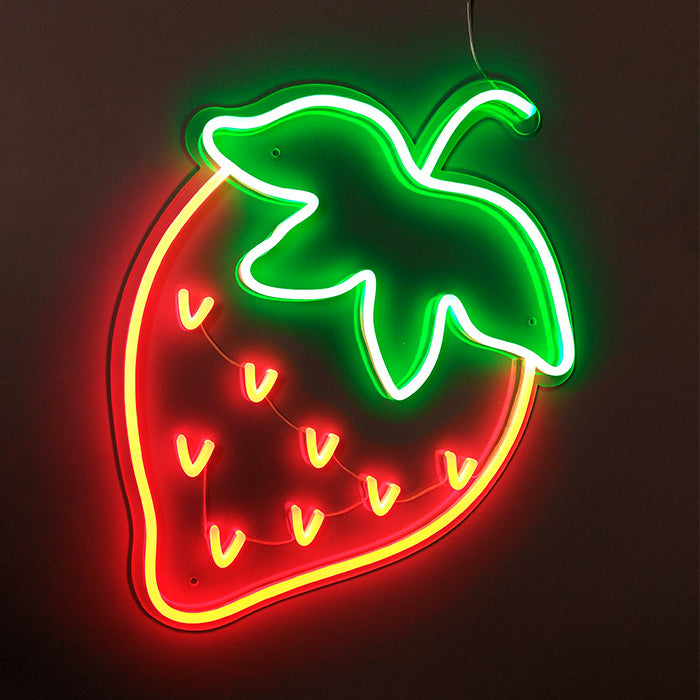 A glowing neon sign of a stylized strawberry with a green leafy top, illuminated on a dark brick wall