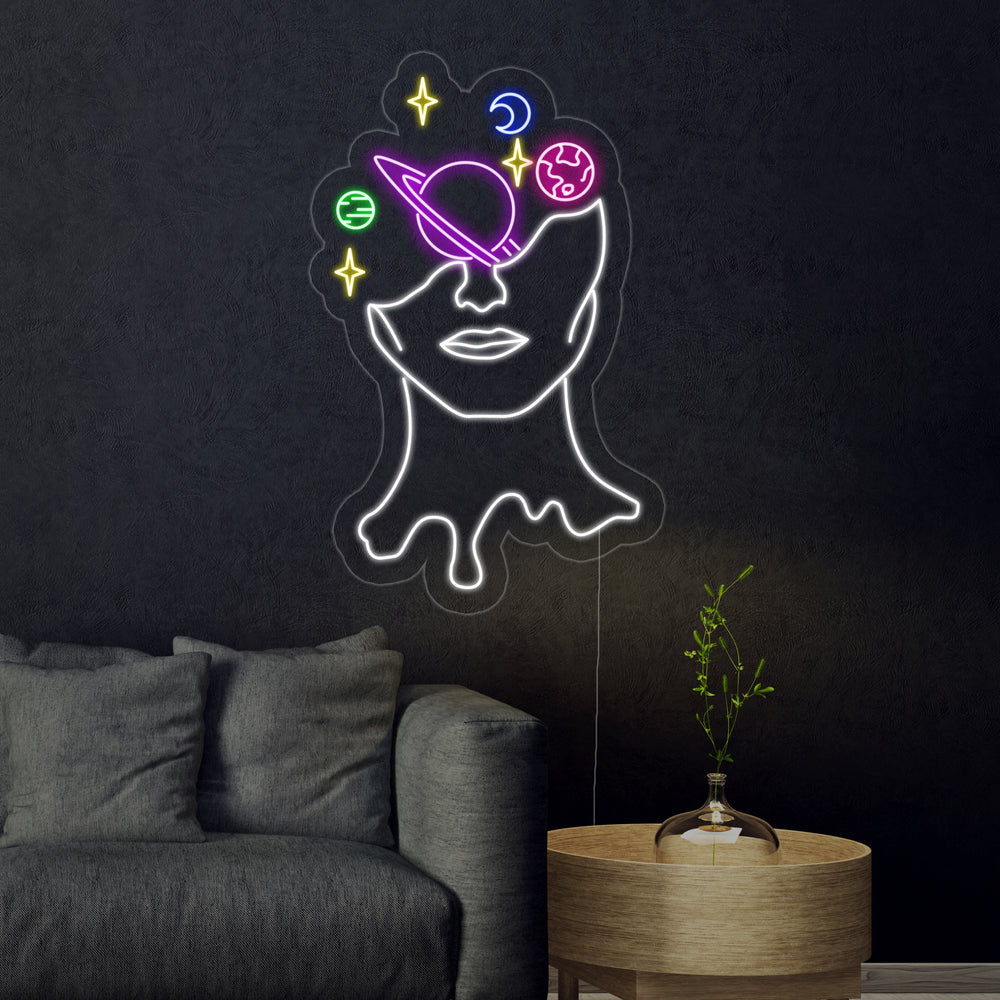 The glowing 'Galaxy Brain' neon sign mounted on a living room wall above a sofa, illuminating the space with its cosmic design.