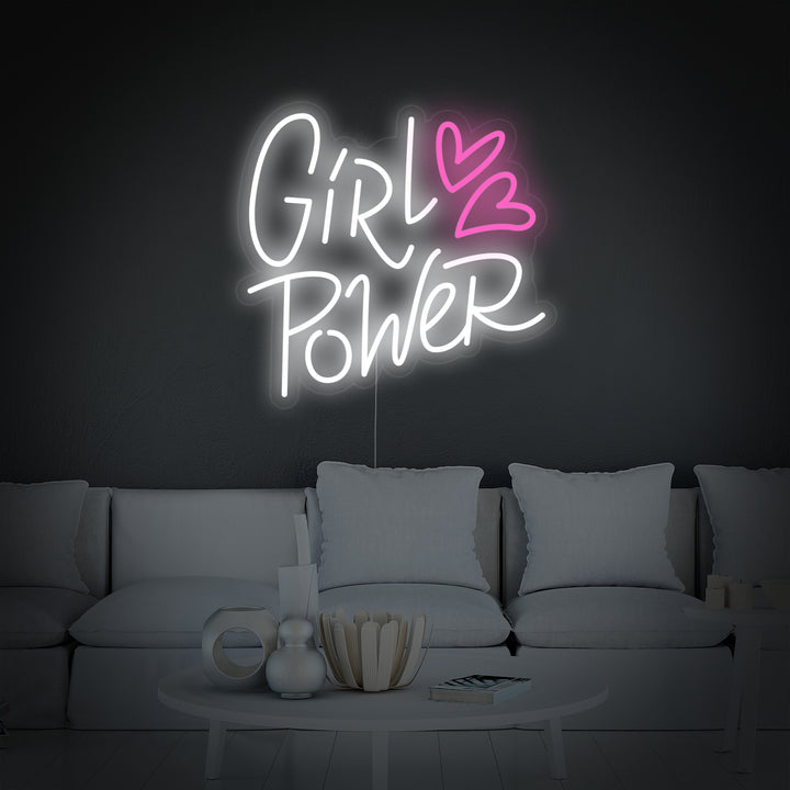 An styled conceptual design visualization of the 'Girl Power Hearts' neon sign glowing on a clean pink wall in a modern room setting.