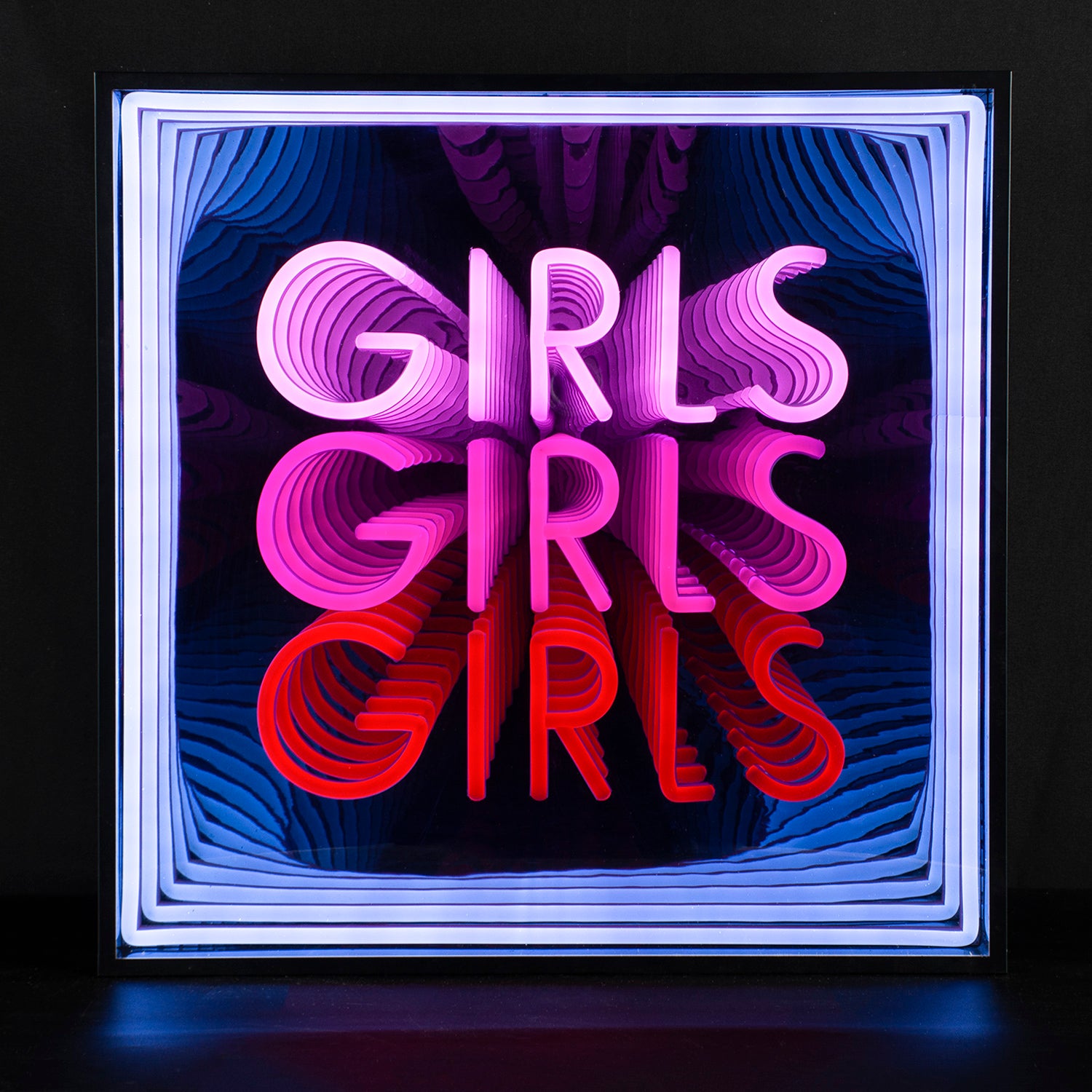 A vibrant photograph of the illuminated 'Girls Girls Girls' 3D infinity neon sign, displaying the repeating orange text glowing brightly within a deep mirror effect, mounted against a rustic dark brick wall.