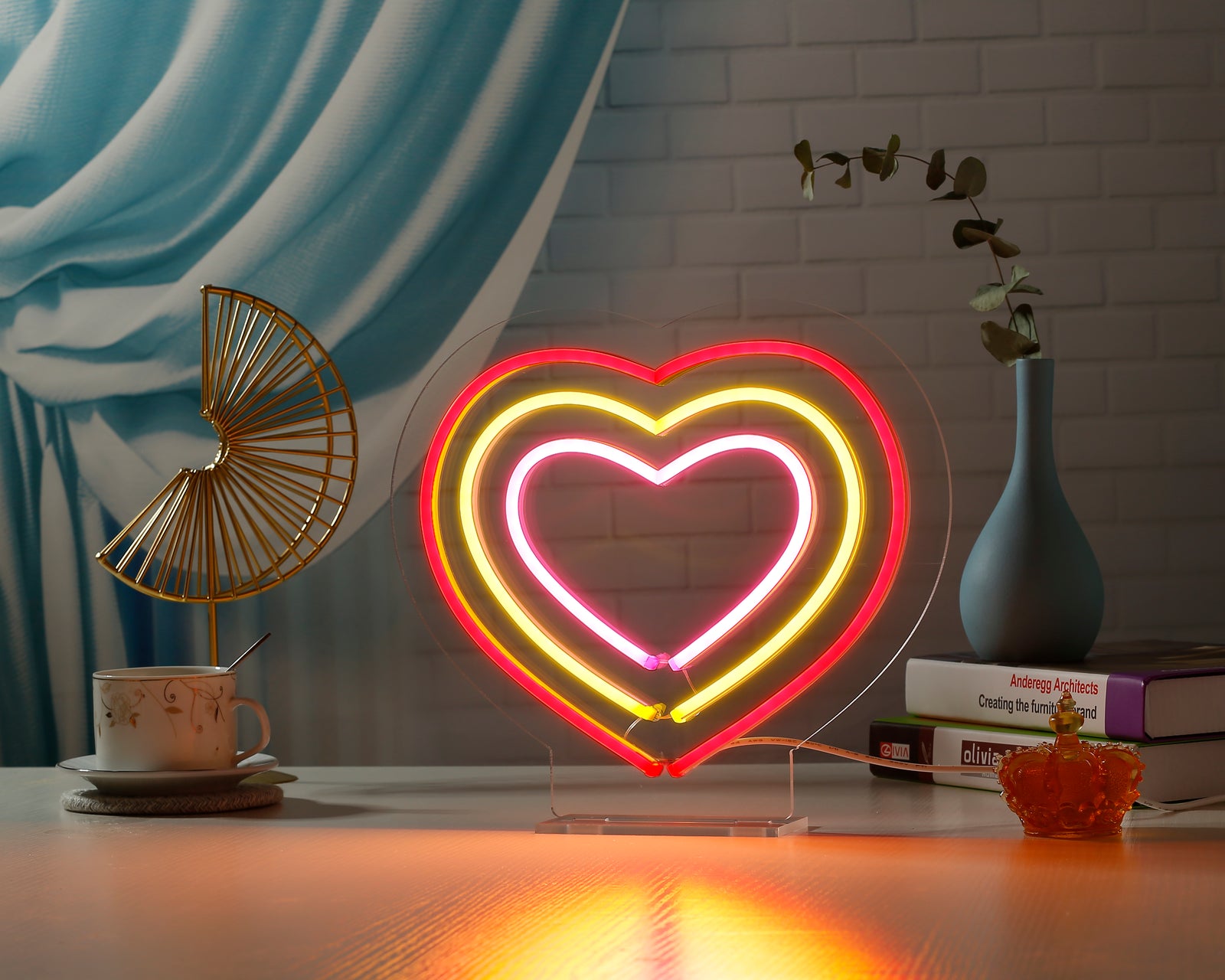 A glowing LED neon desk sign featuring linked white and red hearts on an acrylic stand.