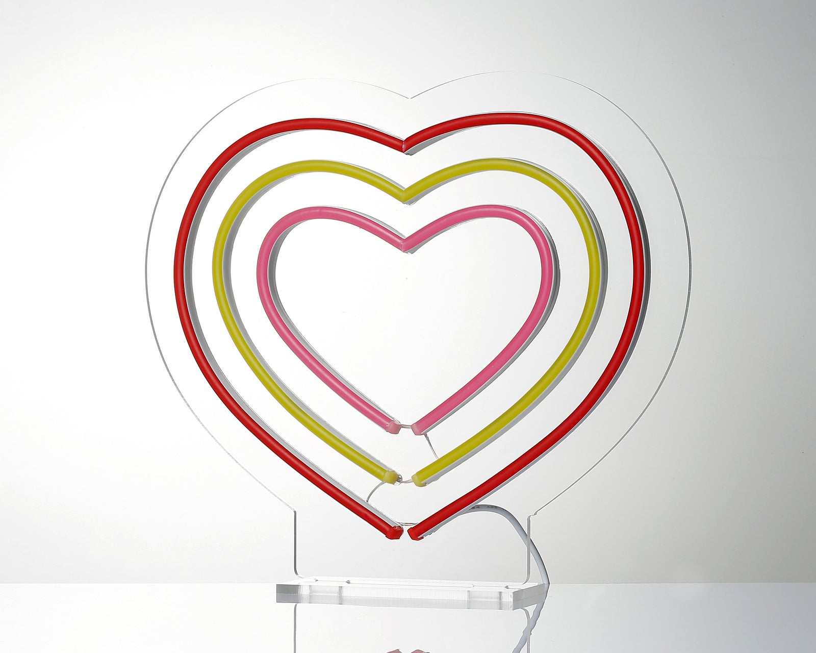 Close-up view of the "Hearts" neon sign illuminated, showing the red and white tubes.