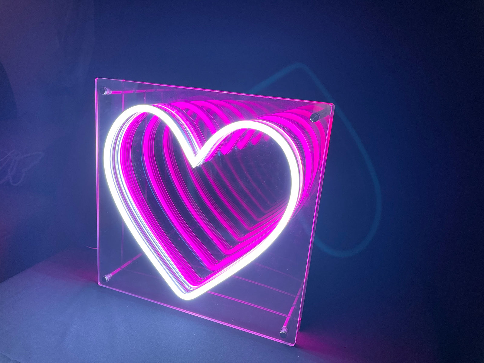 A close-up view of the Hearts LED Infinity Neon Sign glowing against a dark background.