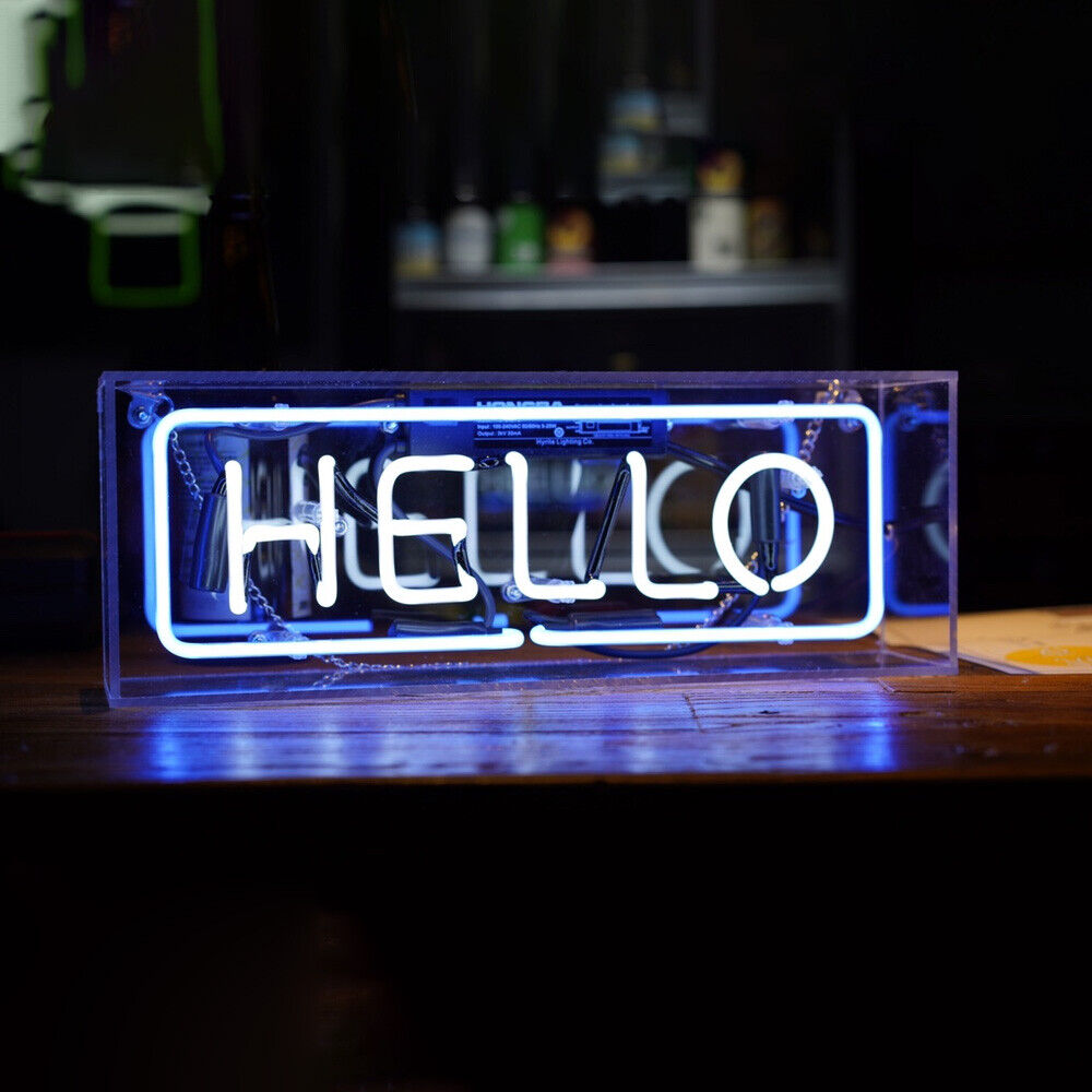 Hello handwritten script neon sign made from glass tubes and mounted inside a clear acrylic box, shown on a rustic wooden table.