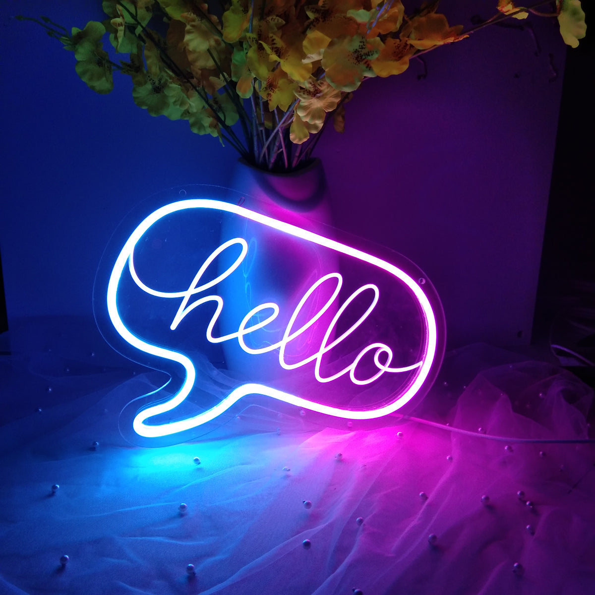 "Hello" mini neon sign glowing warm yellow in a natural script font.