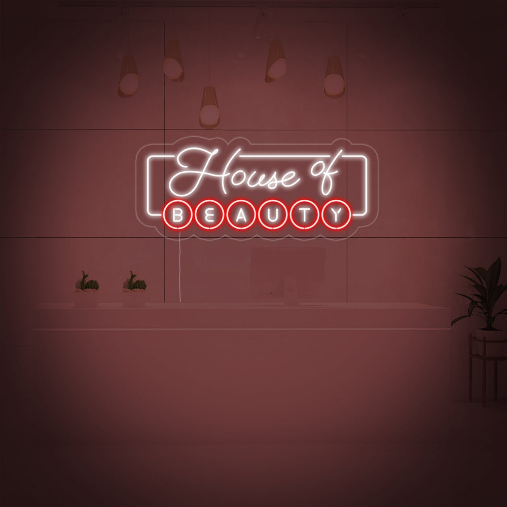 A glowing 'House of Beauty' neon sign is displayed behind a reception desk in a modern beauty salon setting.