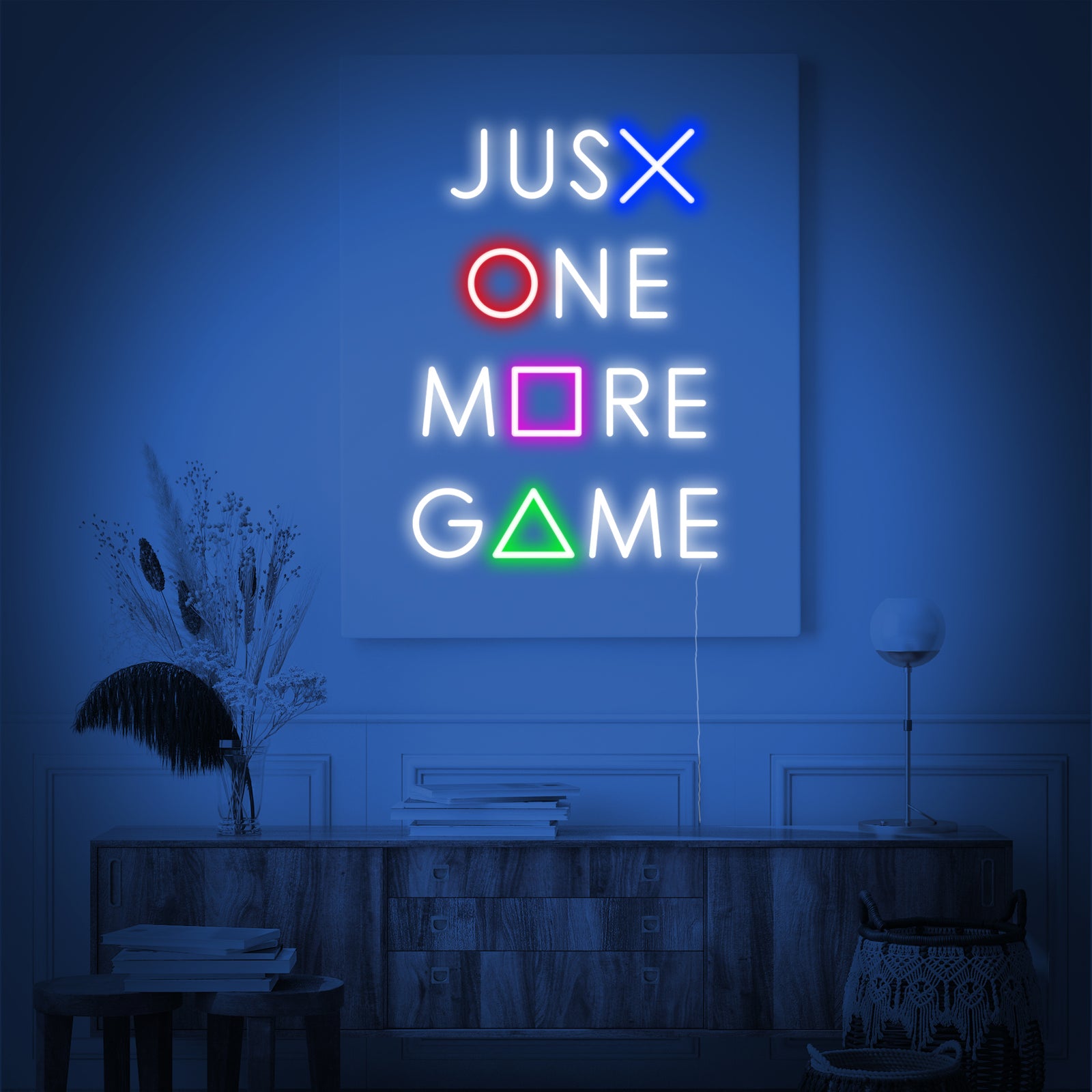 A close-up view of the 'Just One More Game' neon sign showing the distinct glowing tubes against a dark textured wall background.