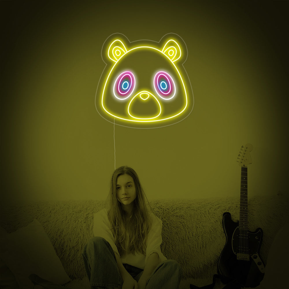 A close-up photograph of the 'Graduation Bear' neon sign, clearly showing the glowing neon tubing shaped into an adorable bear cub with a graduation cap on a clear acrylic background.