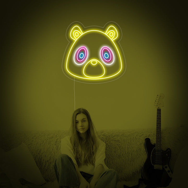 A close-up photograph of the 'Graduation Bear' neon sign, clearly showing the glowing neon tubing shaped into an adorable bear cub with a graduation cap on a clear acrylic background.