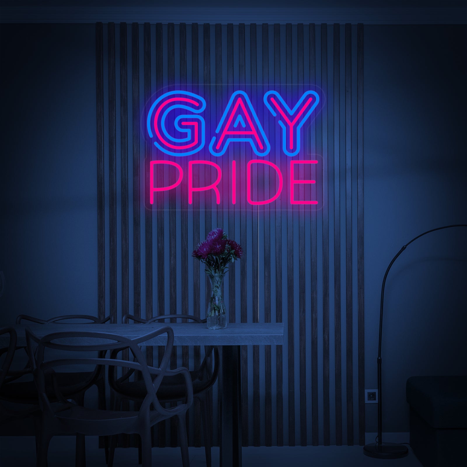 Close-up photograph of a rainbow 'LGBT Gay Pride' neon sign glowing brightly on a textured grey wall, showing the realistic tube design.