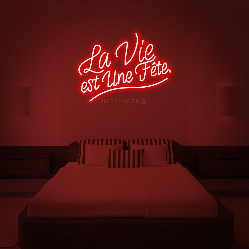 Clean vector mockup of the 'La Vie est Une Fete' neon sign design against a solid red wall backdrop