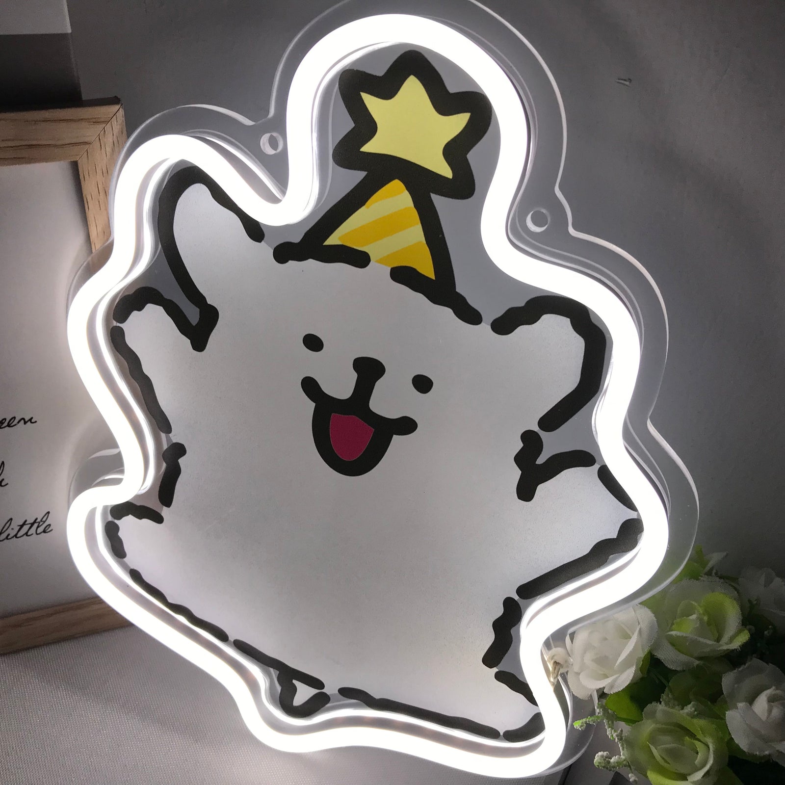 Close-up view of the glowing blue Maltese puppy neon sign on acrylic backing