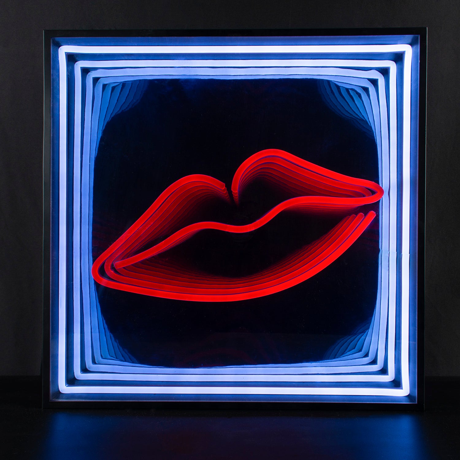 A "Lips" 3D infinity neon sign displaying a mesmerizing tunnel of light effect, photographed against a plain background.