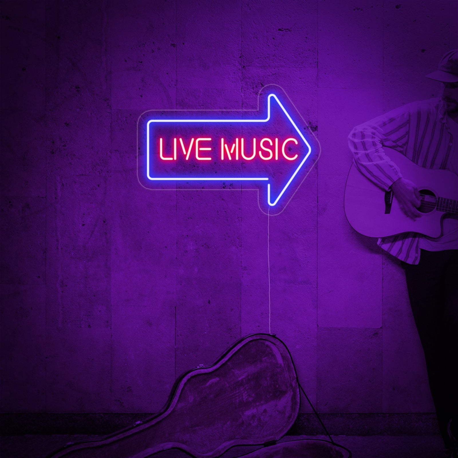 The glowing 'Live Music' neon wall decor is mounted above a musician's keyboard and guitar setup in a cozy home music room.