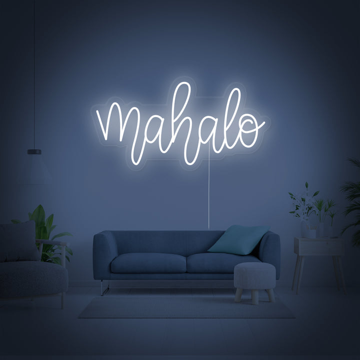 Detailed product shot of the 'Mahalo' neon sign, showing the glowing tubes and backing against a neutral background.