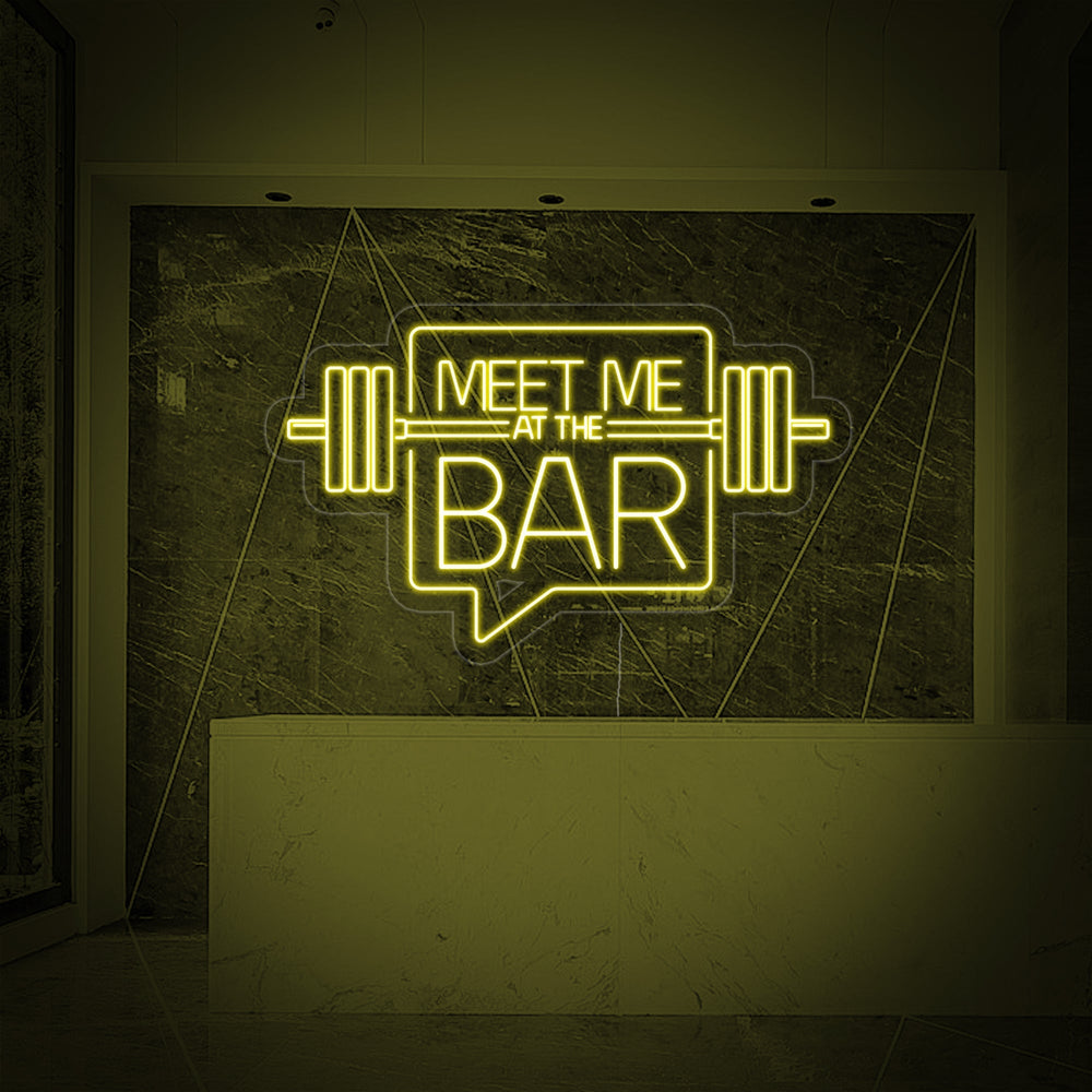 The 'Meet Me At The Bar' neon sign displaying bright, even illumination and clear, legible typography.