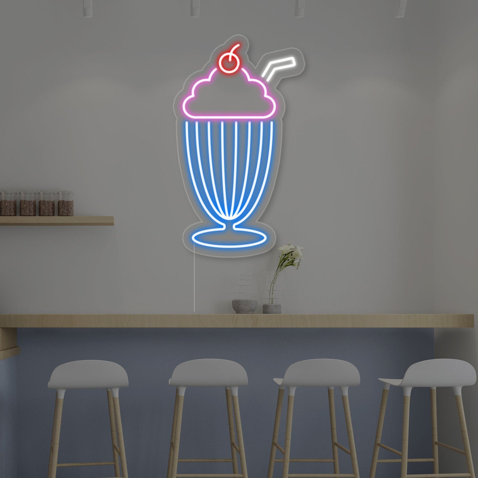 Glowing milkshake neon sign with pink tubing displaying a straw and a cherry, mounted on a wall.