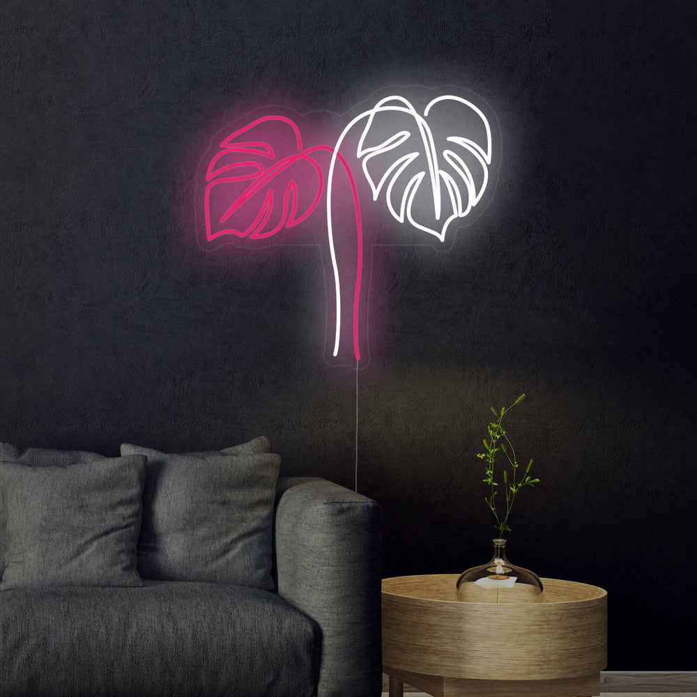 Close-up photograph of a Monstera Leaves neon sign, glowing brightly.