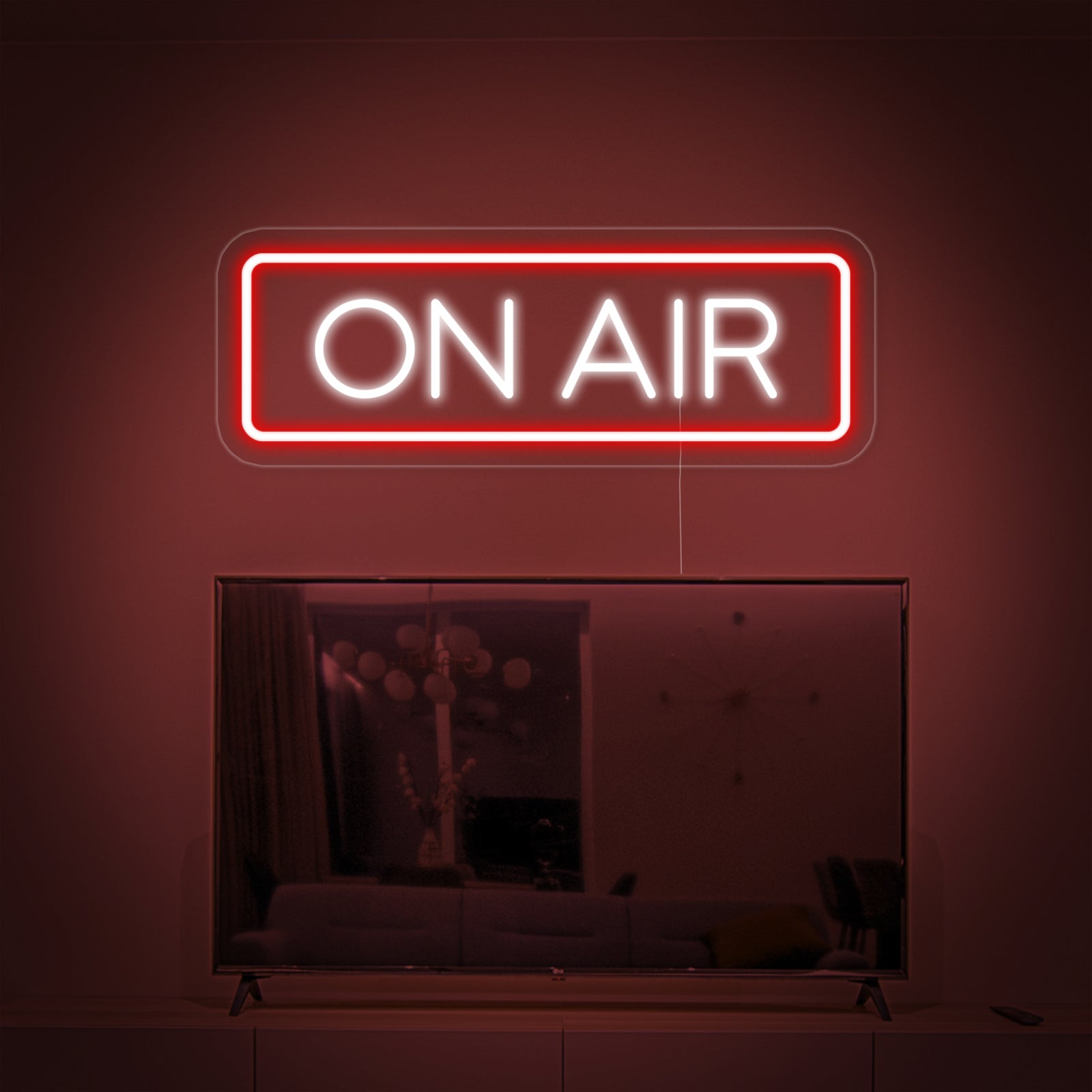 A perfectly composited bright red ON AIR neon sign glowing above a television in a modern living room.