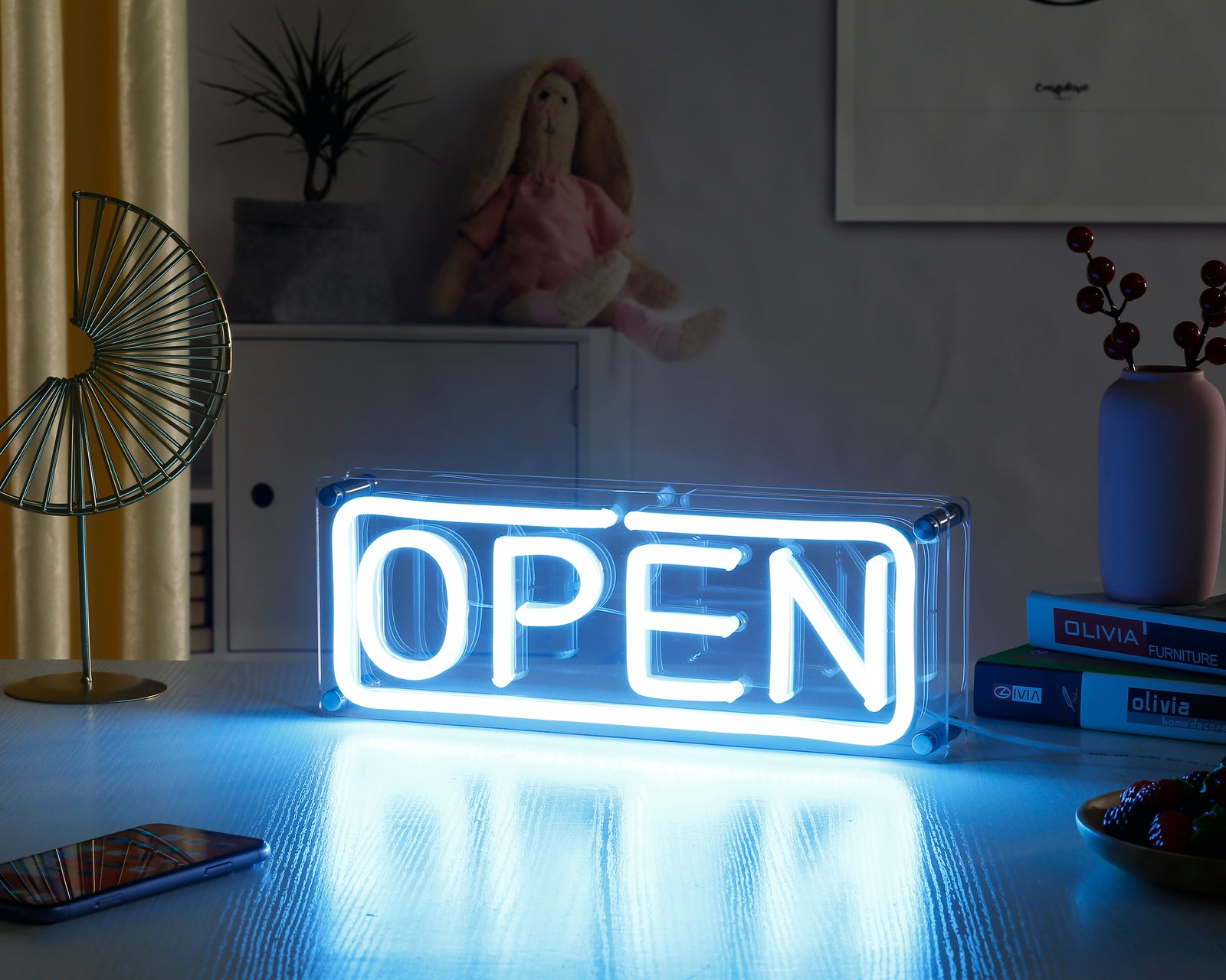 A vibrant 'Open' desk neon sign, glowing red, in clear acrylic casing on a dark tabletop reflecting the light.