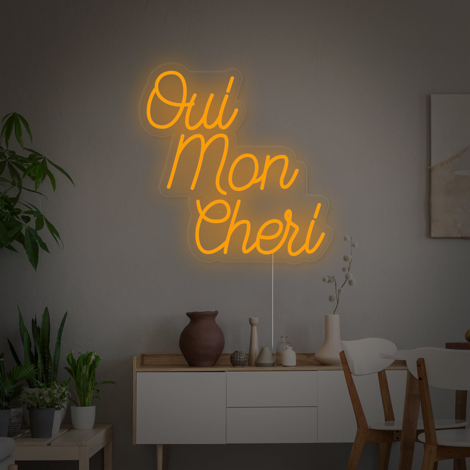 Close-up view of the glowing Oui Mon Cheri neon sign showing the tubing detail and clear acrylic backing