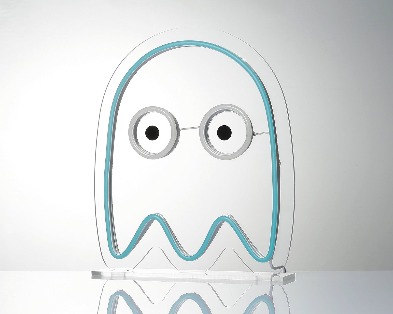 A brightly glowing blue ghost desk neon sign with an intricate tubing design and a clear acrylic stand, shown in a simple studio setting.