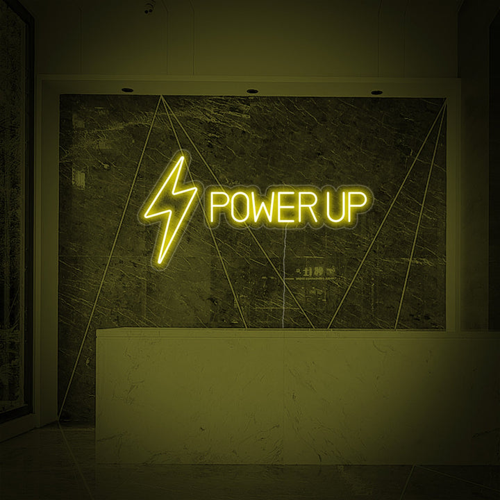 Close-up view of the 'Power Up' neon sign glowing brightly against a sophisticated marble wall in a fitness studio reception area.