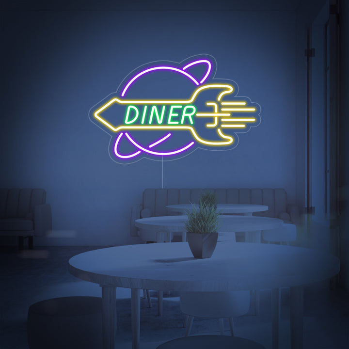 The illuminated ROCKET Rocket Diner neon sign with its blue and red rocket and red script text, showing the physical sign construction and clear acrylic backing.