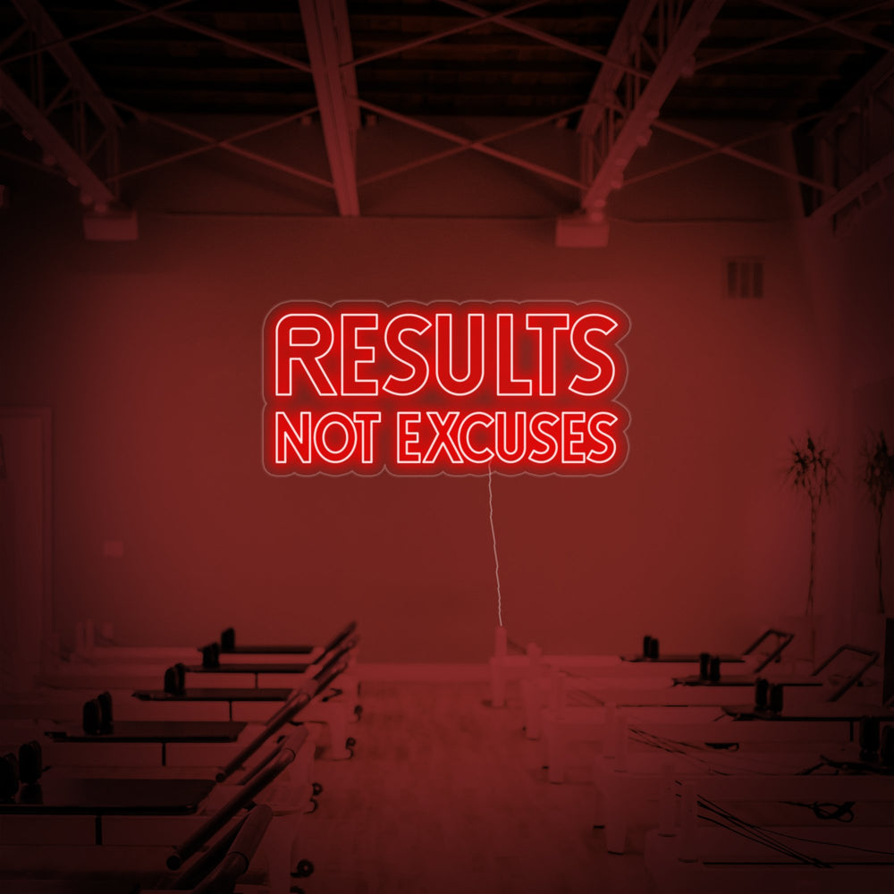 A close-up view of the 'Results Not Excuses' neon sign, showing the clear acrylic backing and the glowing tubing against a simple, light-colored wall.