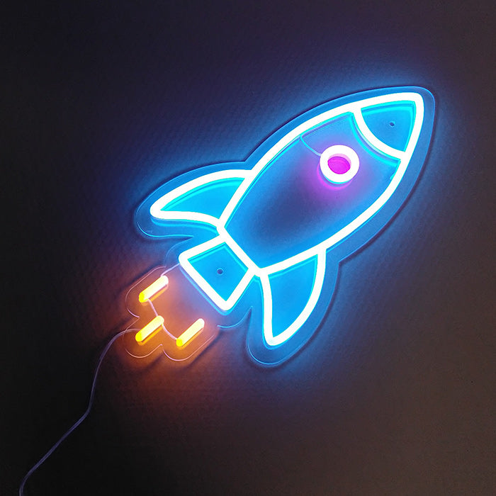 A glowing red and orange rocket ship neon sign mounted on a white wall
