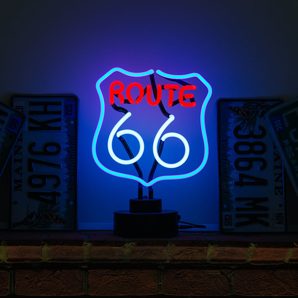 Route 66 table neon sign with blue and white glowing glass tubing on a black base, displayed against a brick wall with US state license plates