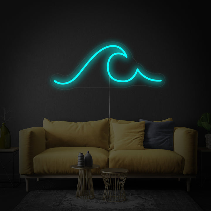 The 'Sea Wave' neon sign showing blue glowing tubing forming a wave shape, mounted on a clear acrylic backing over a textured grey surface next to a teal sofa.