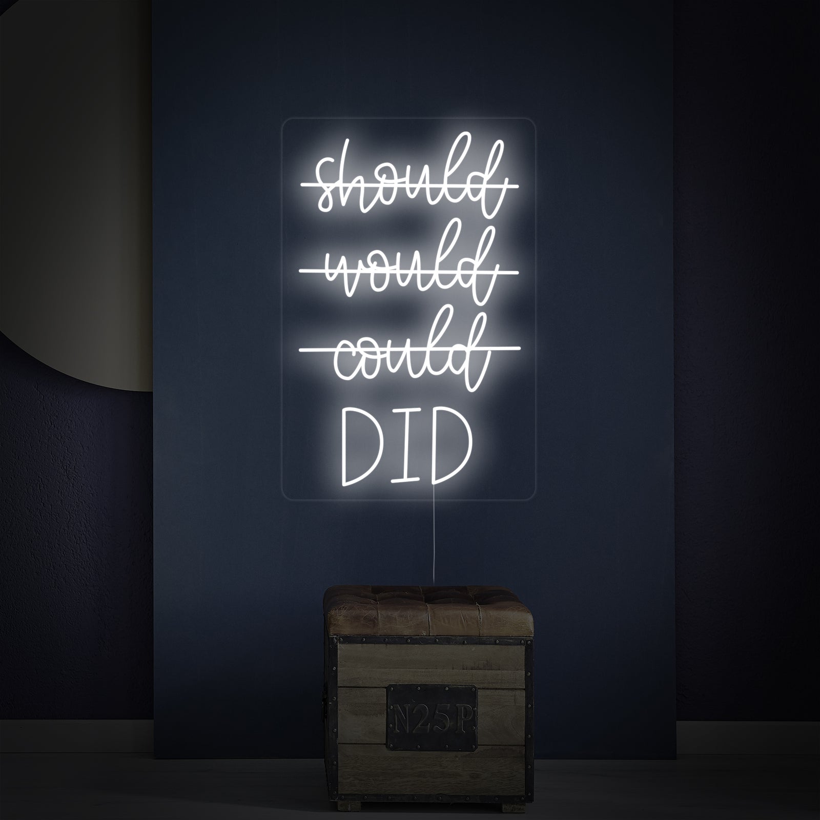Close-up of the 'Should Would Could Did' neon sign over a small wooden chest, emphasizing the glow and specific horizontal line crossing out 'should would could' in the quote.