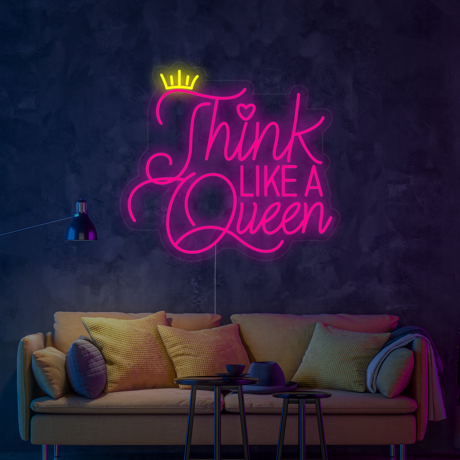 The glowing 'Think Like A Queen' neon wall decor casting a warm glow above a sofa in a modern living room setting.