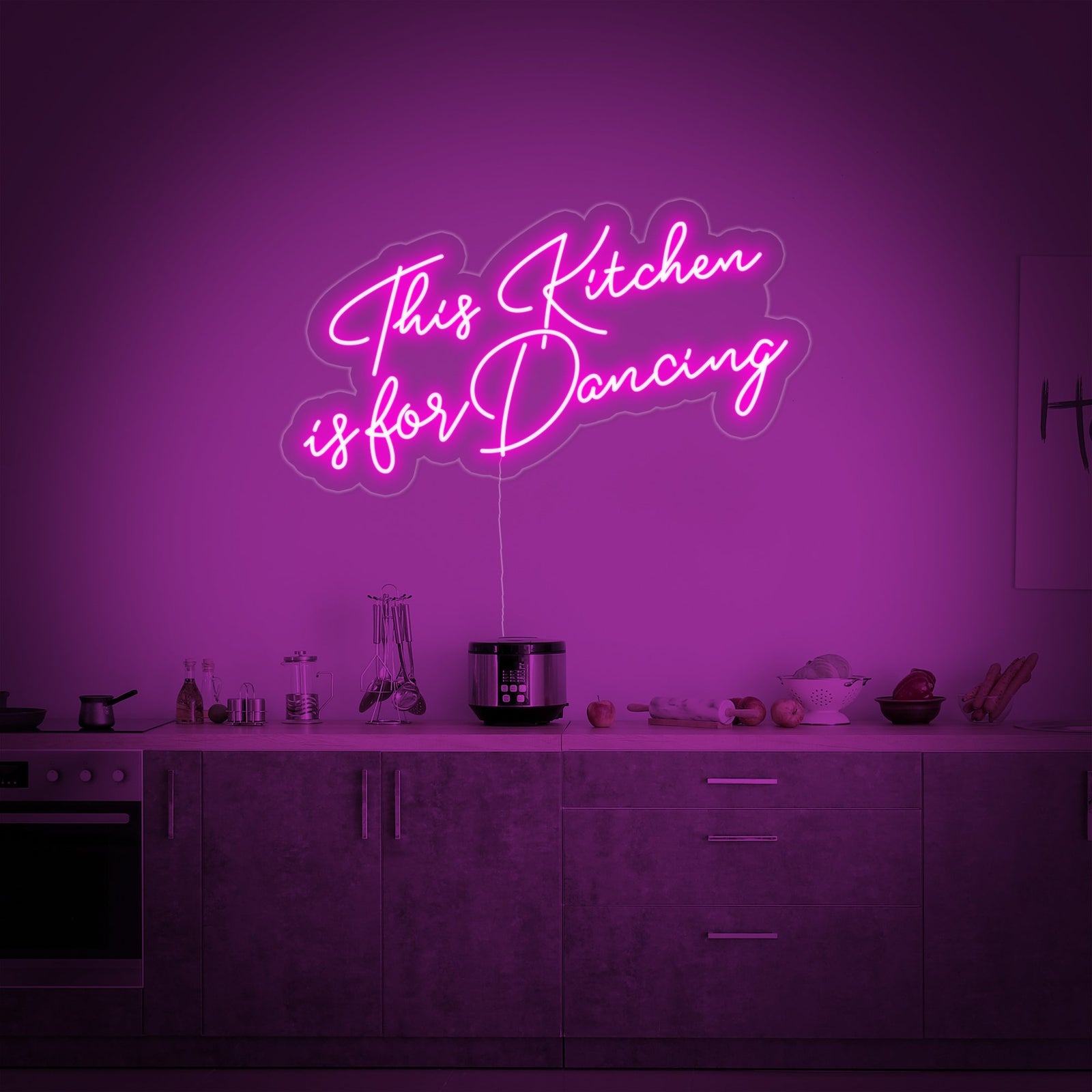 A detailed view of the modern script-style neon sign spelling out 'This Kitchen is for Dancing' mounted on a clear backer.