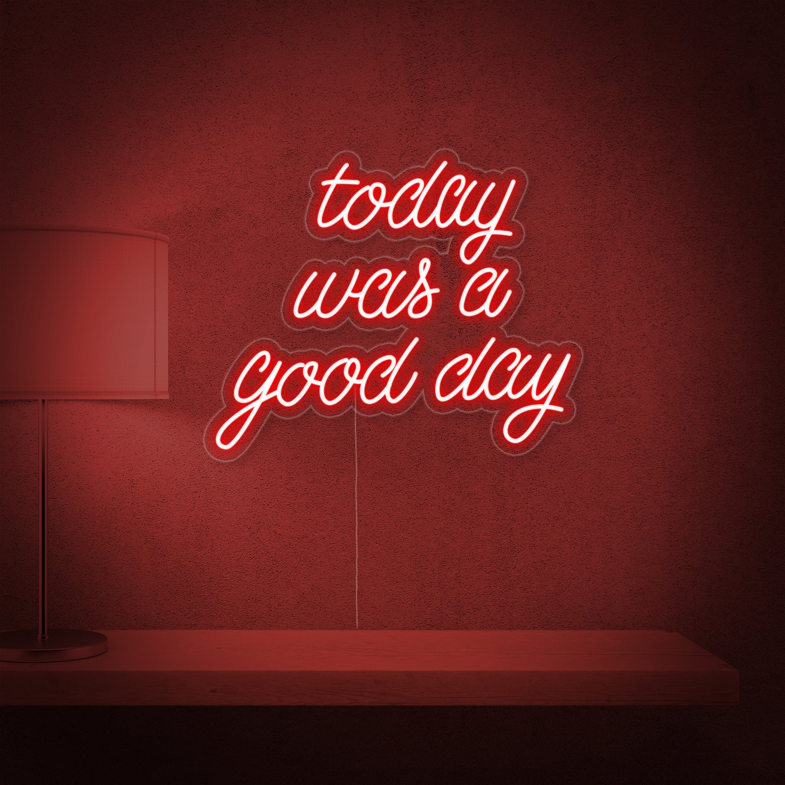A glowing blue neon sign that reads "Today Was a Good Day" against a textured dark blue wall in a modern living space.