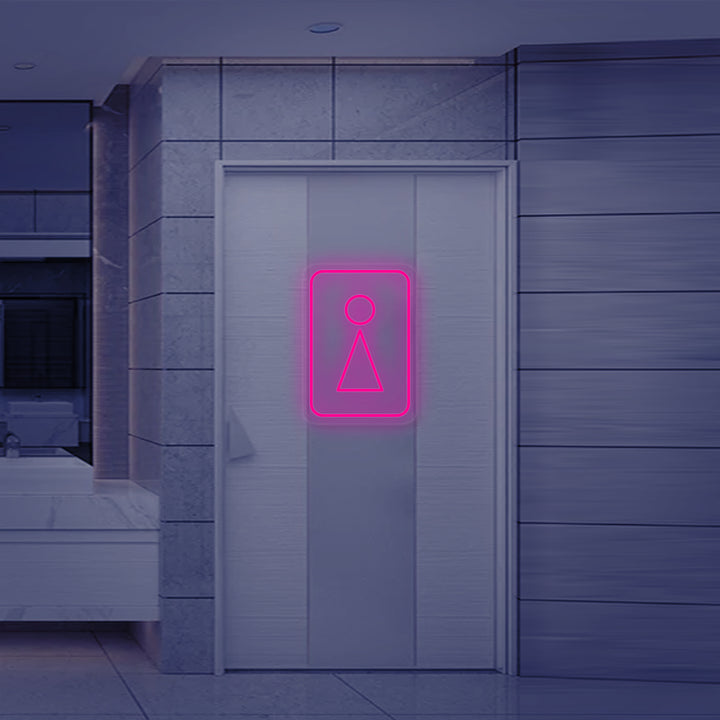 A close-up view of the 'Toilet WC Woman Symbol' neon sign, showing the detail of the luminous tubing and the classic female pictogram design.