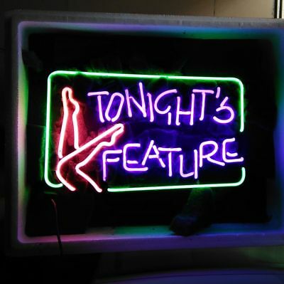 A custom neon sign reading 'Tonight's Feature' glowing in blue, red, and yellow light. The sign is shown in an indoor setting, glowing brightly against a wall.