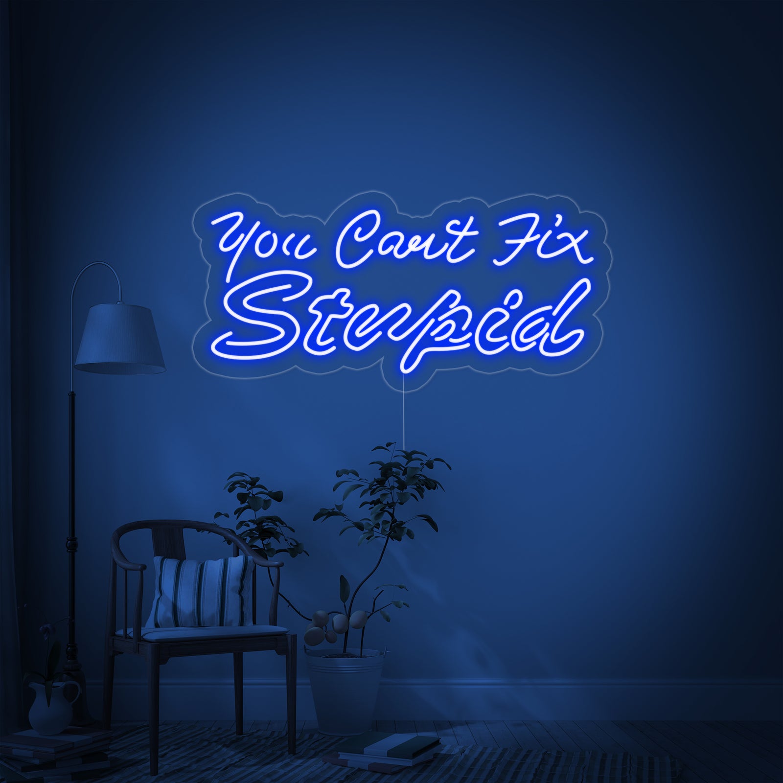 A clean product photograph of the 'You Can't Fix Stupid' neon sign, featuring bright orange text tubes mounted on a transparent acrylic backing cut to shape, glowing brightly against a dark, textured brick wall.