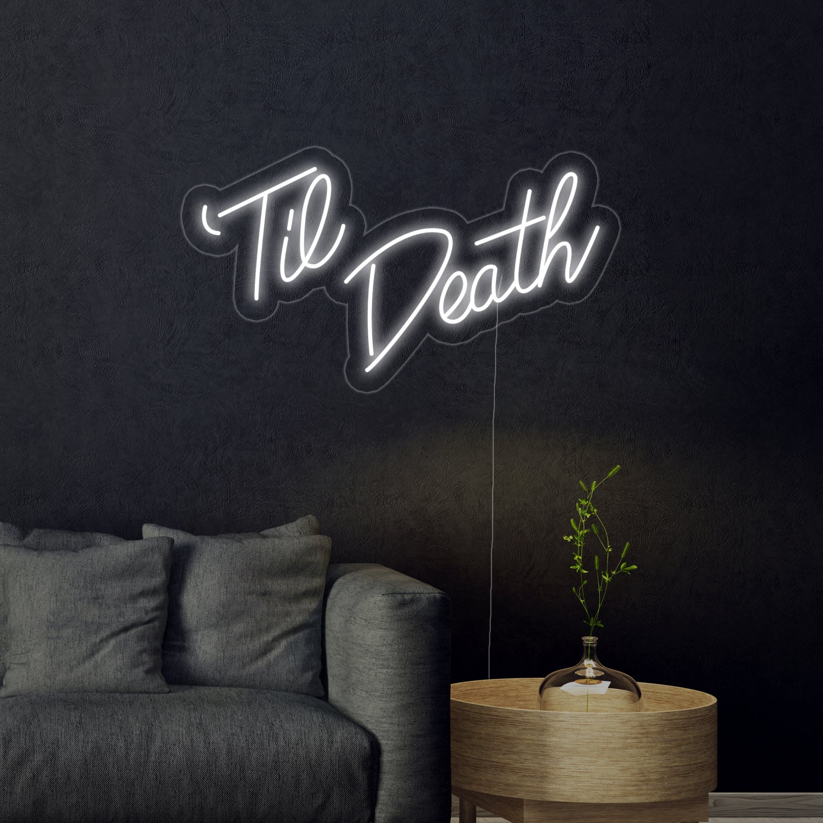 A fabricated "Til Death" neon sign with visible wiring and acrylic backing, hanging against a blurred background.
